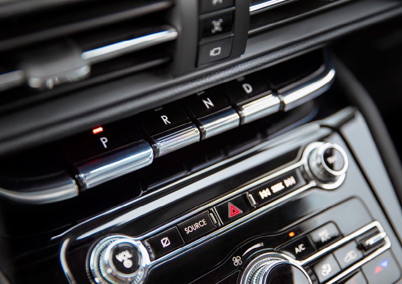 The Park button on the elegant Piano Key Shifter is lit up and engaged as light dances off the chrome accents and horizontal design lines | Mark Ficken Lincoln in Charlotte NC