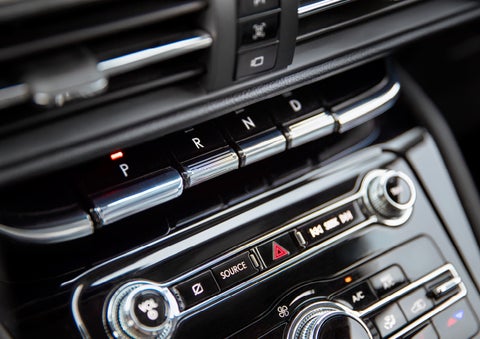 The Park button on the elegant Piano Key Shifter is lit up and engaged as light dances off the chrome accents and horizontal design lines | Mark Ficken Lincoln in Charlotte NC