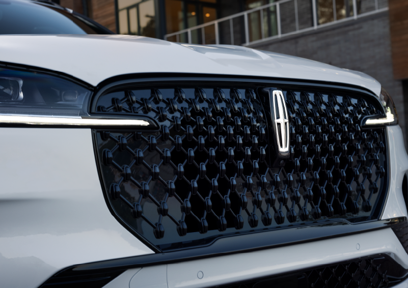 The black grille of a white 2025 Lincoln Aviator® SUV is shown with its fog lights on. | Mark Ficken Lincoln in Charlotte NC