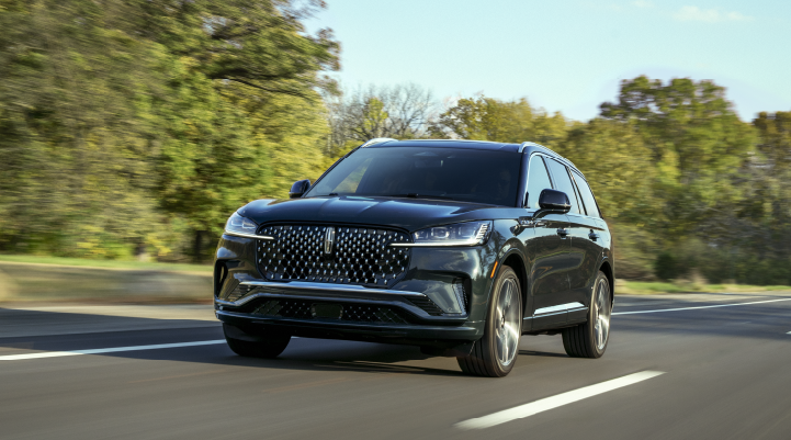 A 2025 Lincoln Black Label Aviator® SUV is being driven down a road lined with trees. | Mark Ficken Lincoln in Charlotte NC