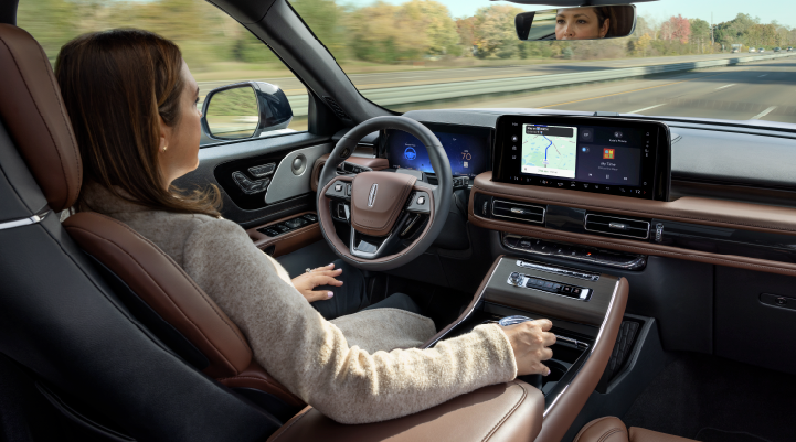 A woman is seen sitting in the driver’s seat of her 2025 Lincoln Aviator® SUV with her hands off the steering wheel. | Mark Ficken Lincoln in Charlotte NC