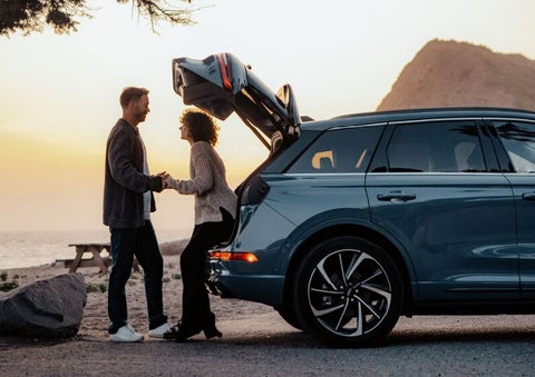 A couple share a moment together outside a 2025 Lincoln Corsair® SUV near the open liftgate. | Mark Ficken Lincoln in Charlotte NC