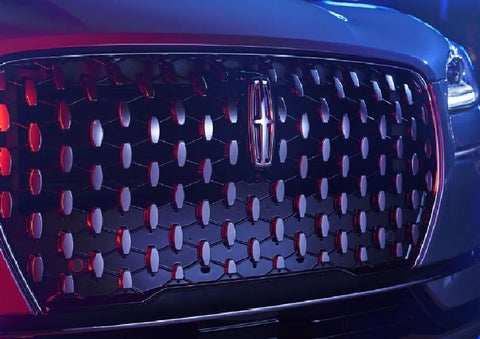 The grille of a 2025 Lincoln Corsair® SUV reflects neon light at night. | Mark Ficken Lincoln in Charlotte NC