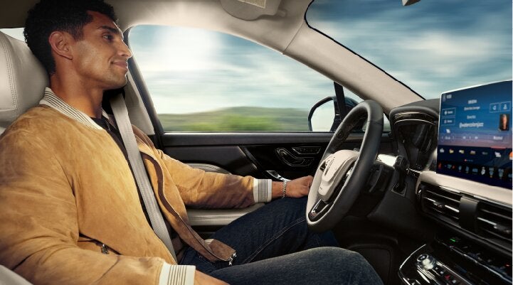 A person is shown using Lincoln BlueCruise hands-free highway driving technology on a divided highway called a Hands-Free Blue Zone. | Mark Ficken Lincoln in Charlotte NC
