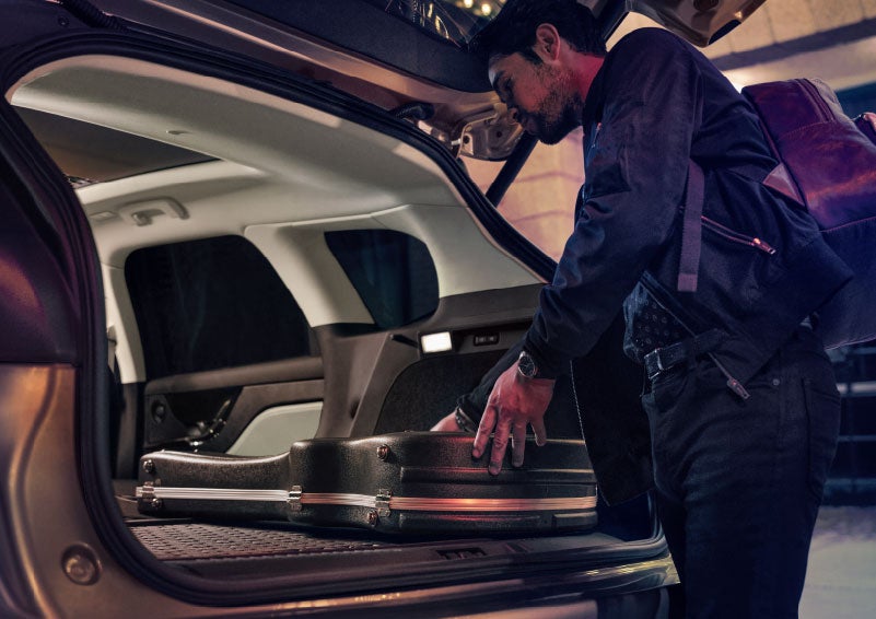 A man is shown loading cargo into the rear of a 2024 Lincoln Corsair® SUV with the second-row seats folded flat. | Mark Ficken Lincoln in Charlotte NC