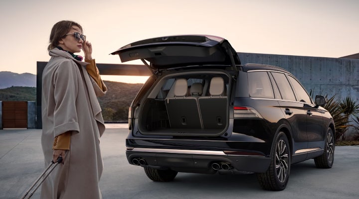A woman approaches a 2026 Lincoln Aviator® SUV with its rear liftgate open. | Mark Ficken Lincoln in Charlotte NC